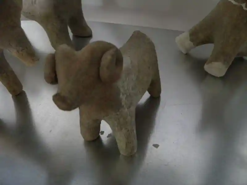 Sheep-like animal with a snout carved on claystone.